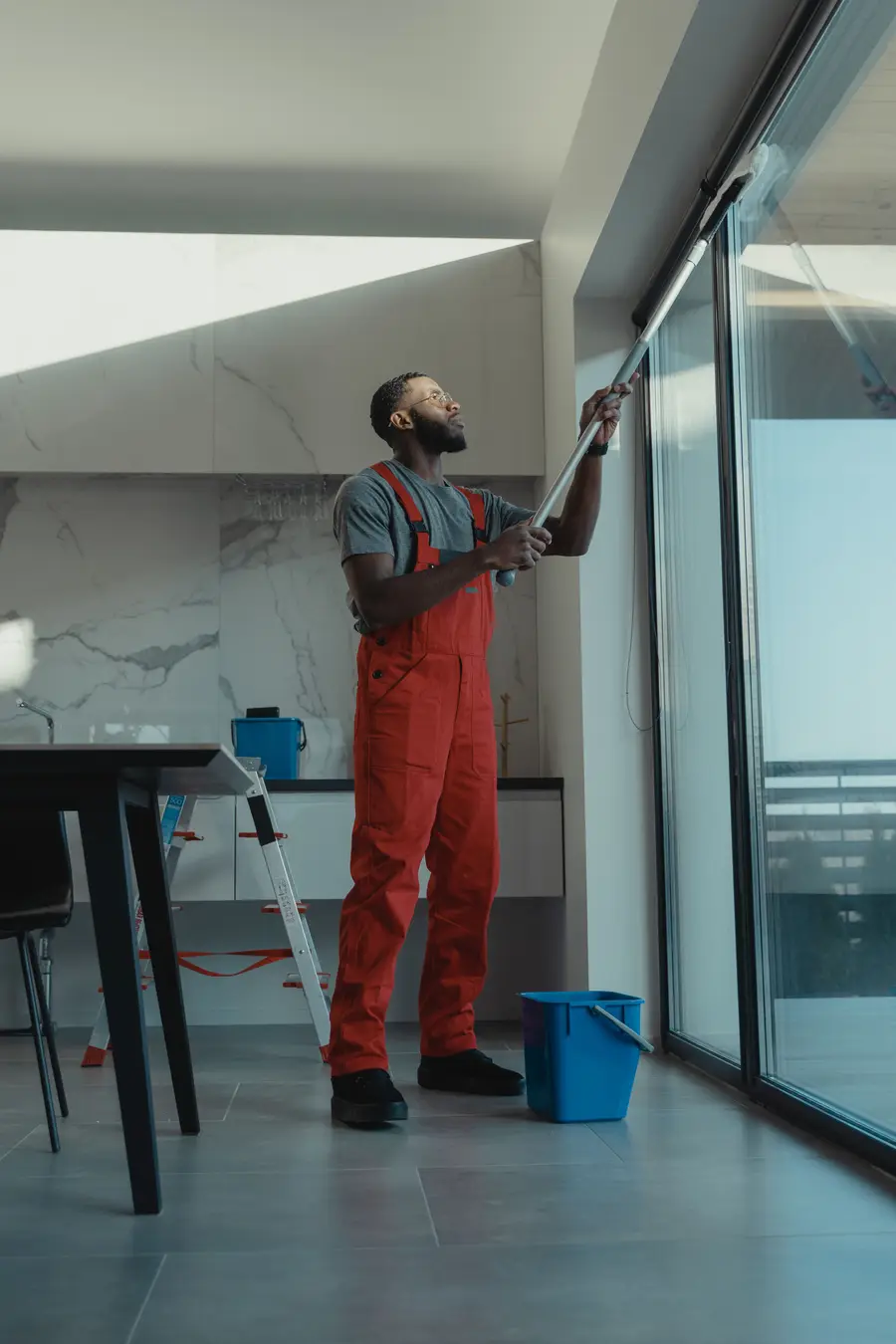 A cleaner keeping the glass and surfaces of a commercial space in Leicester spotless